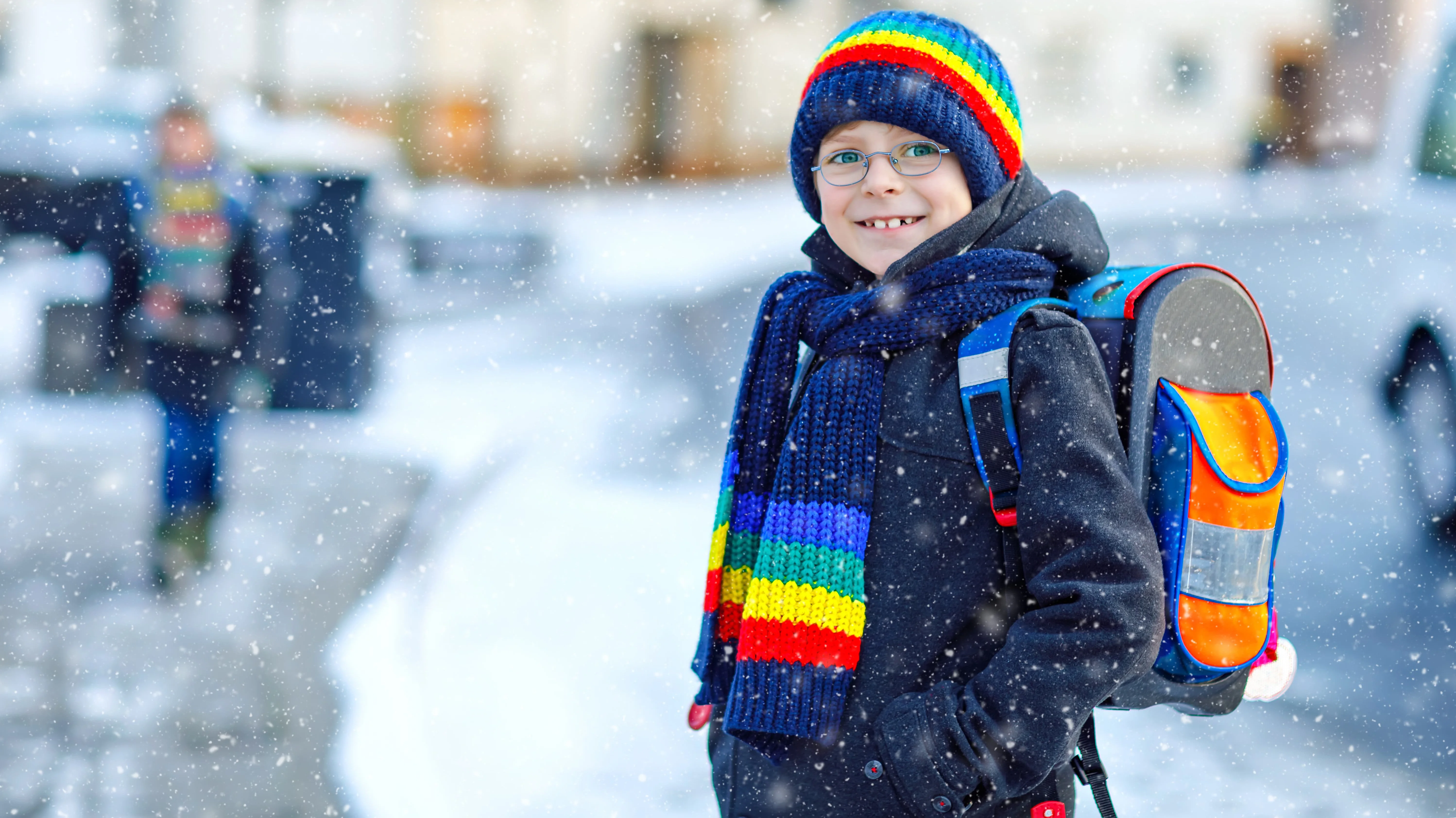 Kind mit Schulranzen im Winter