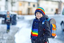 Kind mit Schulranzen im Winter